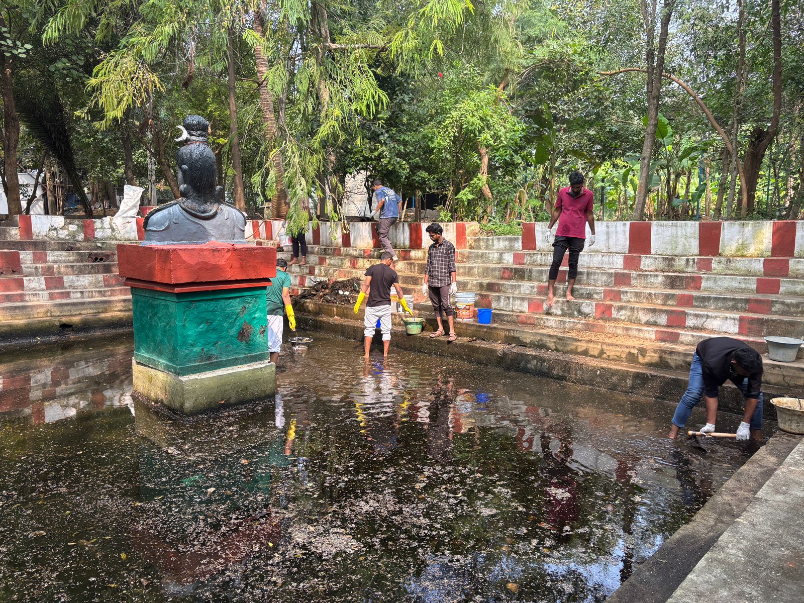 Sanitation drive in progress at a temple pond